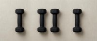 Four black dumbbells arranged in a row on neutral background, isolated and ready for fitness, gym, and wellness design projects.