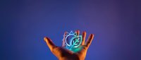 Hand holding glowing holographic brain with digital neural networks on gradient purple blue background for technology and artificial intelligence concepts.