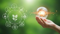 Hand holding glowing light bulb with green energy icons representing renewable power, sustainability and environmental technology solutions.