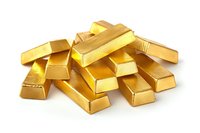 Stack of shiny gold bars scattered on white background, representing wealth, investment and financial success in banking and precious metals market.