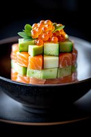 Fresh salmon and cucumber tartare topped with red caviar in black ceramic bowl, elegant Japanese fusion appetizer served on dark background.