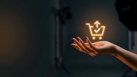 Hand holding glowing shopping cart crown icon against dark background, representing premium retail experience, luxury shopping, and e-commerce success for business and marketing.