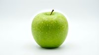Fresh green apple with water droplets isolated on white background, ready for food and nutrition design projects.