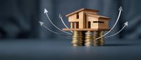 Wooden house model on gold coins with upward arrows showing real estate investment growth and property value appreciation concept for financial planning.