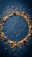 Gold leaf particles scattered in circular frame on deep blue textured background, creating elegant border design. Suitable for luxury branding, invitations, and decorative backgrounds.