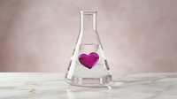 Laboratory flask with pink heart symbol inside representing love chemistry and romantic science concept on wooden surface.