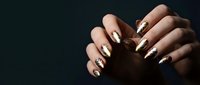 Female hands with elegant black and white nail art design featuring geometric patterns and negative space manicure on dark background for beauty concepts.