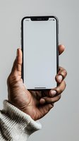 African American hand holding modern smartphone with blank white screen against neutral gray background, perfect for app or website mockup.