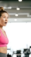 Woman in pink sports bra with shocked expression at gym, fitness motivation and surprise reaction for health and wellness content.