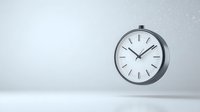 Minimalist wall clock floating against light gray background showing ten past ten, modern round timepiece with metallic frame and clean design.