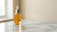 Luxury golden serum bottle with dropper on marble surface in bright natural light. Premium skincare product for anti-aging and moisturizing treatments.