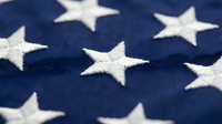Close-up detail of white embroidered stars on blue fabric showing patriotic textile craftsmanship and national symbolism for Memorial Day celebrations.
