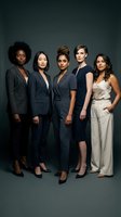 Group of five diverse women in professional business attire standing together against neutral background. Features women of various ethnicities wearing blazers and formal clothing for corporate, leadership, and team concepts.
