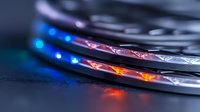 Colorful LED strip lights creating dynamic illumination effect with red and blue glowing on black surface, close-up macro photography showing modern lighting technology.