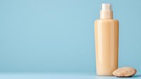 Minimalist cosmetic bottle and natural stone on blue background. Skincare product mockup for beauty and wellness branding and packaging design.