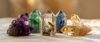 Colorful healing crystals and gemstones arranged in row including amethyst fluorite quartz citrine for meditation spiritual wellness energy work decoration.