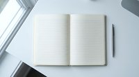 Open blank lined notebook with pen on white desk in bright minimalist workspace, ready for writing, planning, or journaling.