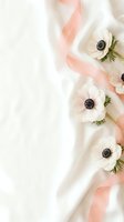 White anemone flowers with coral pink ribbon on soft fabric background for wedding invitations, feminine branding and romantic design projects.