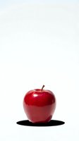 Fresh red apple with glossy skin isolated on white background for healthy eating and nutrition concepts.