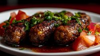 Grilled meat balls with fresh herbs and tomato sauce on white plate for restaurant menu and cooking recipes.