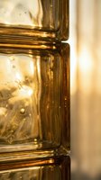 Golden liquid in glass bottle with bubbles and light refraction, suitable for cosmetics, skincare, perfume, and wellness product packaging design.