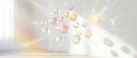 Floating translucent spheres in soft pink, yellow and clear tones with light rays and bokeh effects on neutral background for design projects.