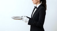Professional waitress in black uniform holding silver serving tray, hospitality service worker isolated on white background for restaurant industry designs.