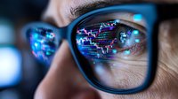 Close up view of stock market trading charts and data reflected in blue-framed glasses lens, showing financial market analysis and digital technology concept.
