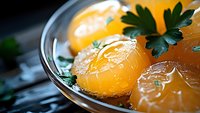 Fresh raw egg yolks in glass bowl with parsley garnish on dark background, extreme close up with selective focus. Culinary and gastronomy concept.