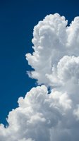 Dramatic white cumulus clouds against deep blue sky creating natural atmospheric background for weather and climate concepts.