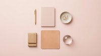 Minimalist flat lay composition with natural wooden and pink stationery items arranged on soft blush background for branding and design projects.