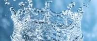 Dynamic water crown splash with flying droplets on a blue background, capturing motion and freshness in a stunning macro shot.