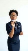 Professional African American businesswoman in navy suit blowing whistle against white background for corporate training and leadership concepts.