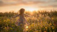 Young girl with curly hair wearing a floral dress spinning in a wildflower meadow at golden hour sunset, arms outstretched in joy and freedom among blooming yellow flowers.