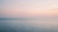 Serene ocean horizon at dawn with soft pink and blue tones, calm waters meeting peaceful sky, suitable for wellness and travel backgrounds.