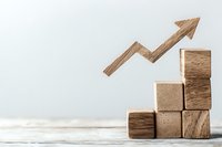 Wooden blocks arranged as steps with upward trending arrow, symbolizing business growth, success and progress on light background with copy space.