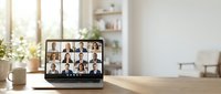 Remote team video conference call on laptop screen in modern home office workspace with natural lighting and minimalist decor for business communication.