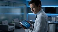 Professional Caucasian male doctor using digital tablet in modern hospital room with blue ambient lighting for medical technology and healthcare innovation.
