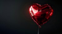 Red heart-shaped balloon floating against dark background creates romantic mood and symbolizes love, celebration, and special occasions. Perfect for Valentine's Day designs.