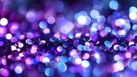 Magical purple and blue bokeh lights creating dreamy abstract background with blurred glowing circles and sparkles. Festive holiday atmosphere.