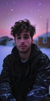 Young man with dark curly hair and light skin, wearing black quilted jacket, gazes at camera against purple and pink twilight sky with magical sparkles and snowy urban backdrop.