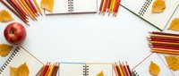 Autumn school supplies frame with colorful pencils, notebooks, red apple and golden leaves on white background. Back to school concept for education.