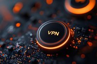 Glowing orange VPN button on dark circuit board with bokeh light effects, representing digital security and private network connection technology.