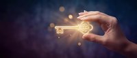 Hand holding glowing golden key with house symbol against dark blue background with bokeh lights for real estate and property investment concepts.