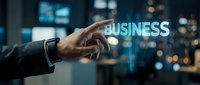 Professional businessman touching glowing BUSINESS text with finger against blurred city lights background at night for corporate presentations.