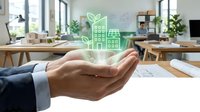 Businessman holding glowing green sustainable building icon above desk with solar panels and eco-friendly office environment, representing renewable energy and green business solutions.