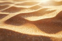 Shimmering golden sand dunes with sparkling particles creating abstract waves and patterns in warm sunlight, macro photography showing detailed texture and depth.