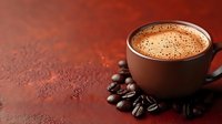 Fresh brewed espresso in brown ceramic cup with roasted coffee beans scattered on dark textured background, selective focus on foam crema.