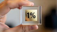 Hand holding transparent glass cube with golden 1% symbol inside representing small percentage, minimal growth or low interest rate concept.