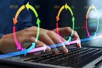 Software development lifecycle concept with hands typing on laptop showing colorful circular arrows and agile methodology stages for project management.